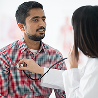 Patient and doctor using stethoscope